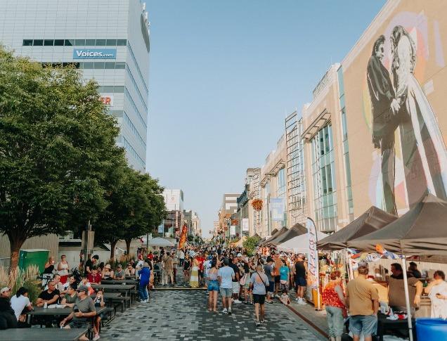 A colourful and busy street of people during an outdoor festival in London, Ontario.