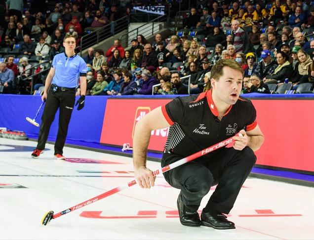 Two curlers playing curling in front of a large audience at Budweiser Gardens located in London, Ontario