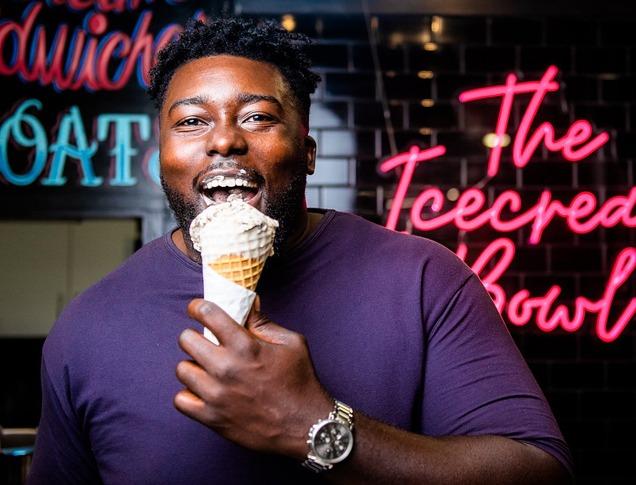 A male smiling and enjoying an ice cream cone from The Ice Cream Bowl located in London, Ontario