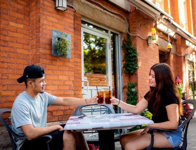 A couple clinks their drinks on the patio of Church Key Bistro and Pub in London, Ontario