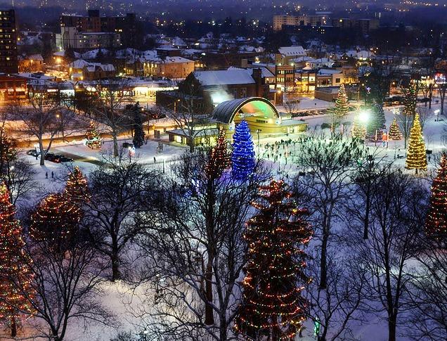 Aerial view of Victoria Park with lit up trees and people skating on the ice rink during the holiday season located in London, ON