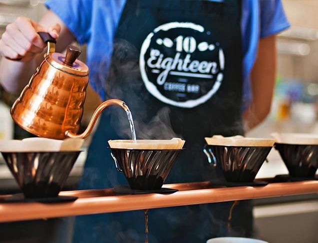 A Barista pouring water into a coffee filter