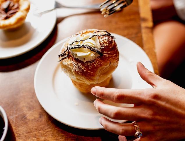 A person about to eat a pastry called a 'cruffin' from Black Walnut Bakery Café located in London, Ontario