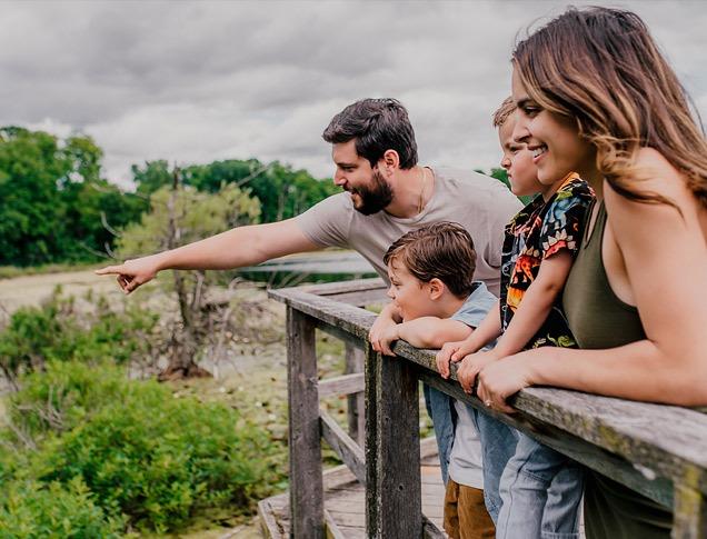 A family standing at a dock overlooking Westminster Ponds located in London, Ontario