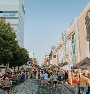A colourful and busy street of people during an outdoor festival in London, Ontario.