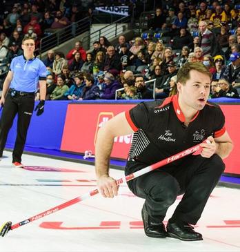 Two curlers playing curling in front of a large audience at Budweiser Gardens located in London, Ontario