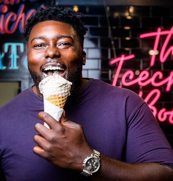 A male smiling and enjoying an ice cream cone from The Ice Cream Bowl located in London, Ontario