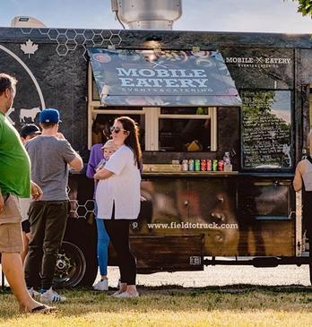 People standing in front of a food truck waiting to order from Field to Truck in London, Ontario