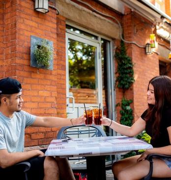 A couple clinks their drinks on the patio of Church Key Bistro and Pub in London, Ontario
