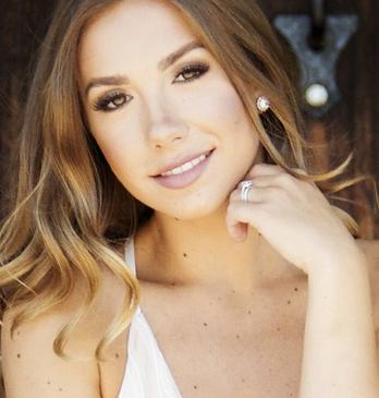 Female country Musician Genevieve Fisher standing in front of fence