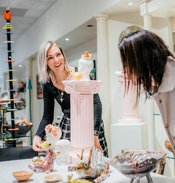 Two women looking at various pieces of ceramic art in the Jonathon Bancroft-Snell Gallery located in London, Ontario, Canada.