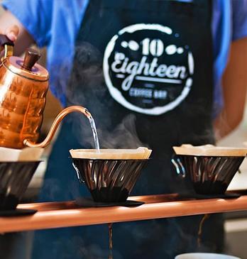 A Barista pouring water into a coffee filter