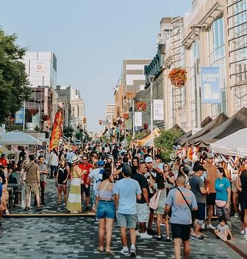 A colourful and busy street of people during an outdoor festival in London, Ontario.