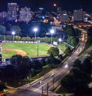 Aerial view of Labatt Park at night with the skyline of the city of London, Ontario in the background
