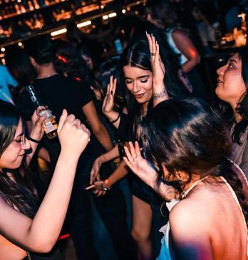 A group of young women dance at Tamasha Bar + Indian Kitchen in London, Ontario.