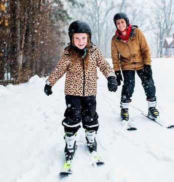 A mother and daughter ski together on a trail at Boler Mountain in London, Ontario
