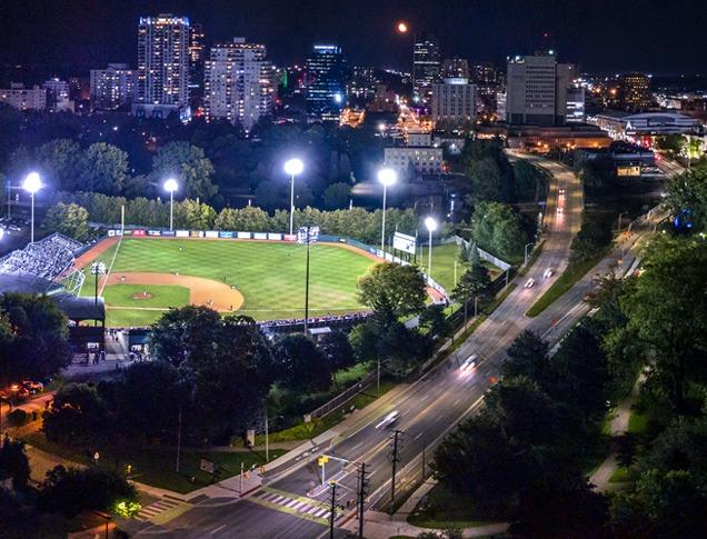 Aerial view of Labatt Park at night with the skyline of the city of London, Ontario in the background