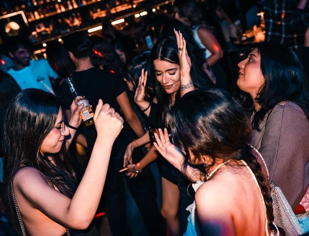 A group of young women dance at Tamasha Bar + Indian Kitchen in London, Ontario.