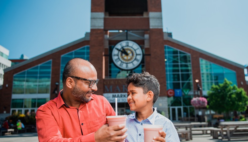 A man and his son enjoying a smoothie on a Covent Garden Market Picnic table