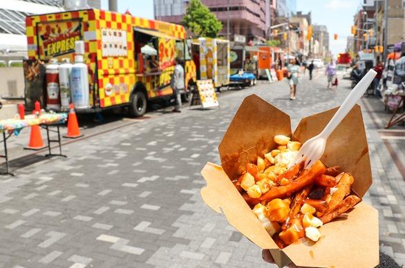 A hand holding a bowl of vegan friendly food from a food truck in London, Ontario