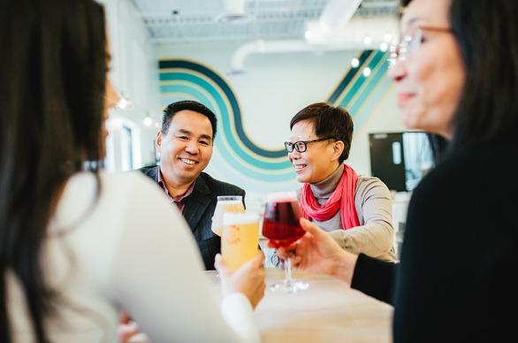 A group of people seated at a table enjoying a glass of beer at Storm Stayed Brewery in London, Ontario