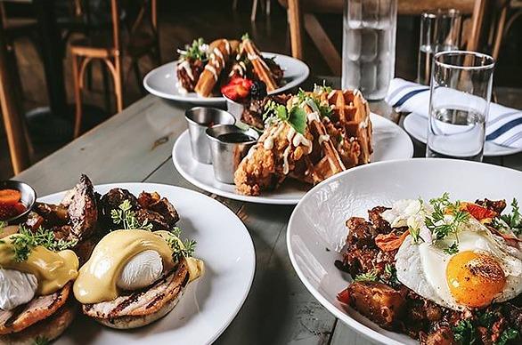 three plates of brunch inspired food on a grey wooden table