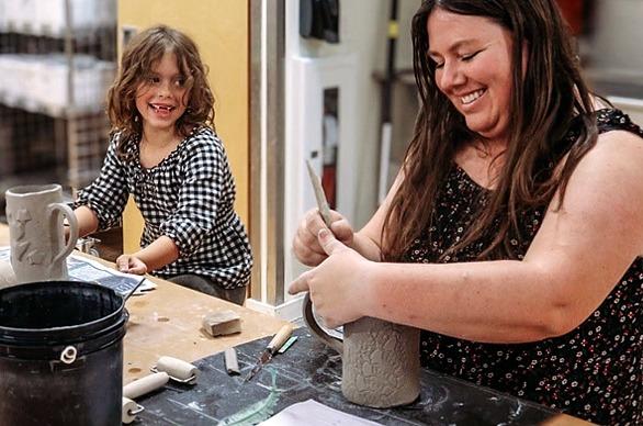 A mother and daughter molding and decorating cups from clay at Clayworx located in London, Ontario