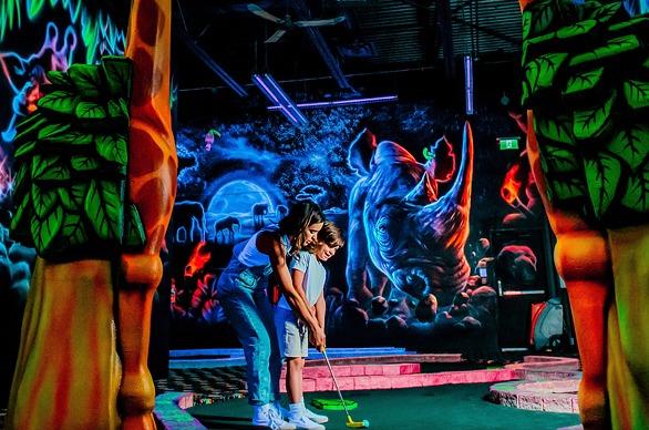 A family having fun playing indoor min golf at Fleetway in London, Ontario