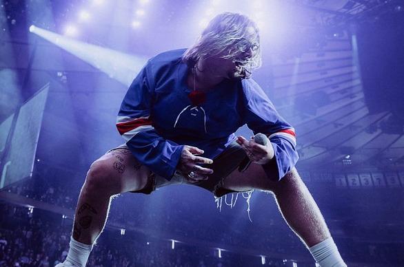 Musician Hardy performing live on stage in a large venue