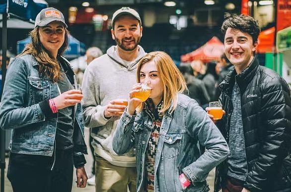 A group of friends holding cups of beer at the I Heart Beer Festival
