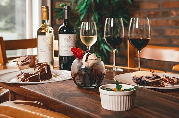 A table setting with various dishes, two bottles of wine and filled glasses from Five87 Bistro, located in London, Ontario