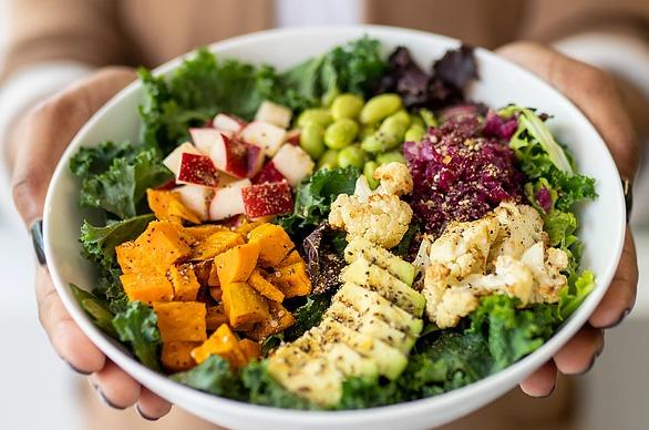 Hands holding a healthy salad bowl from The Green Window located in London, Ontario