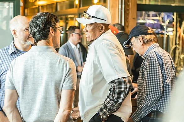 A group of people speaking with Baseball Legend Fergie Jenkins