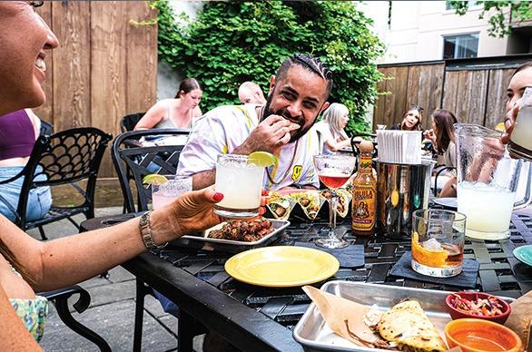 A couple enjoying tacos and beverages at the outdoor patio of The Mule restaurant in London, Ontario