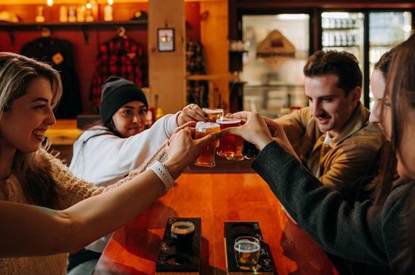 A group of people raising thier glasses of beer at Powerhouse Brewing located in London, Ontario