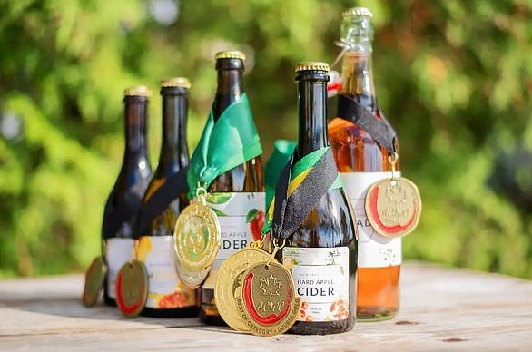 Various bottles of Cider on display with medals draped on them from Heeman’s