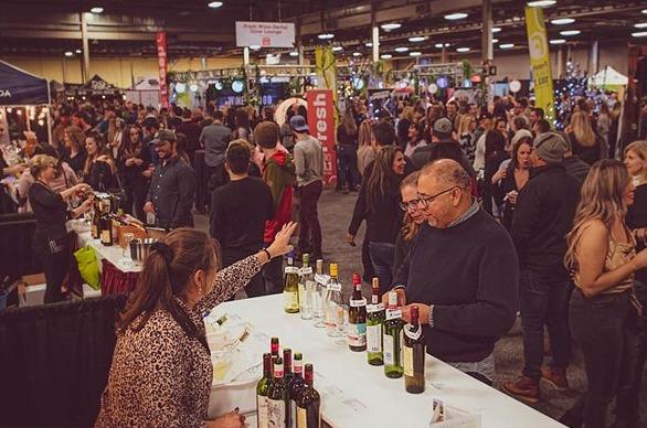A large crowd of people gathered indoors at the Wine & Food Show located at the Western Fair District in London, Ontario