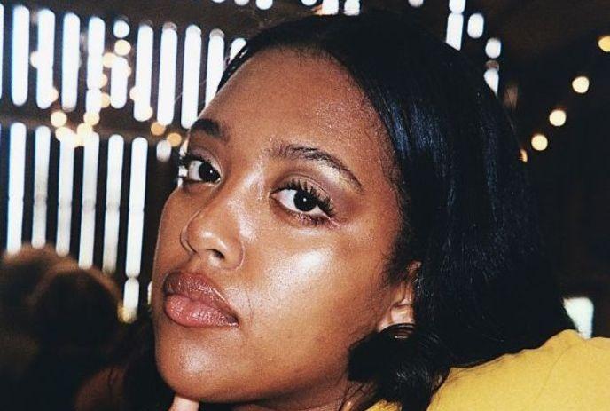 A headshot of Fiker in front of bright lights.