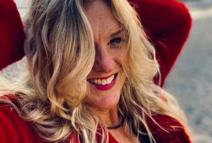 Allyson Morris wearing a red top and smiling for the camera outside.