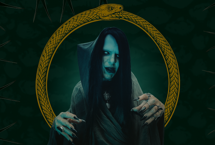 Person in dark robe with ouroboros backdrop, pentagram pendant, rings, and eerie green-toned setting.
