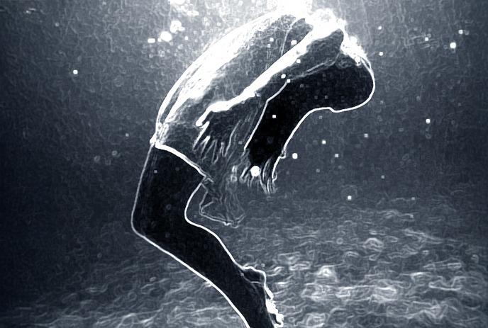 A person dives underwater with light rays and bubbles surrounding them in a dark aquatic scene.