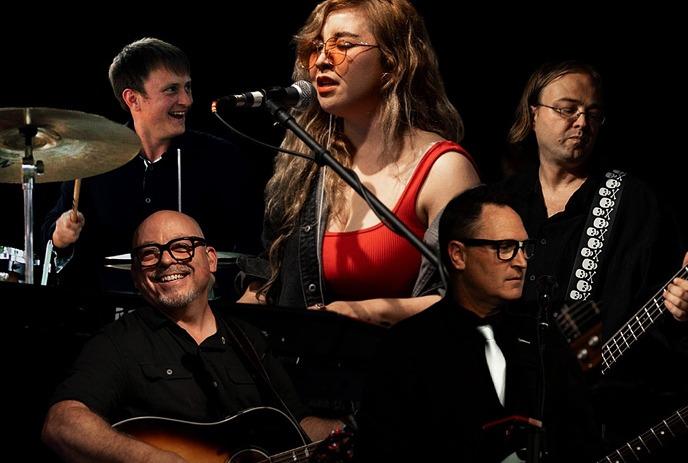 Gravity Junky Band performing live on stage with vocals and instruments.