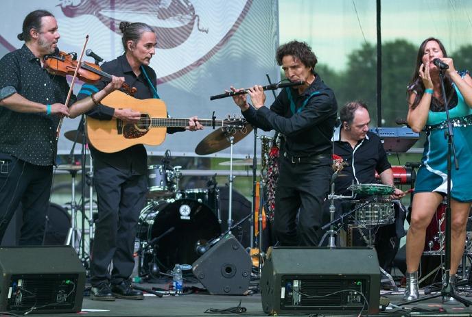 A lively band performs on an outdoor stage.