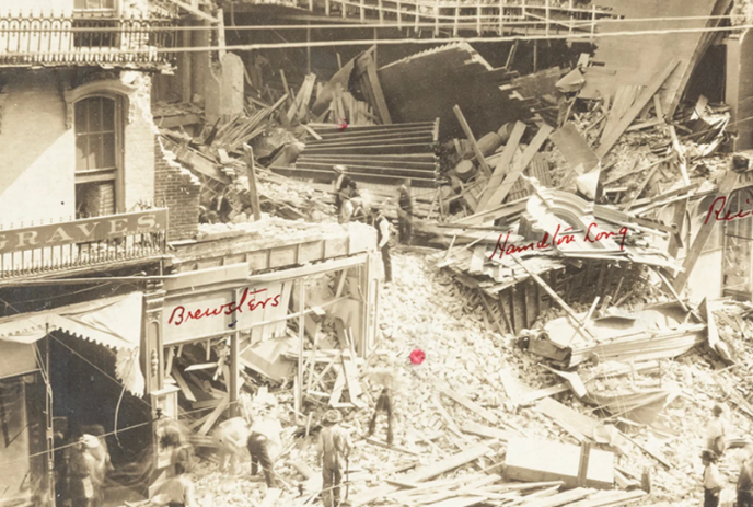 Sepia image of people sifting through some wreckage in London.
