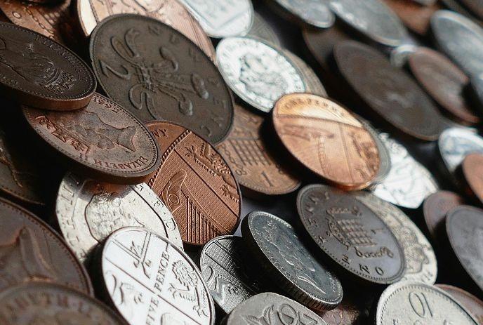 Close view of mixed coins showing varied metals, shield details, and textured engraved designs.