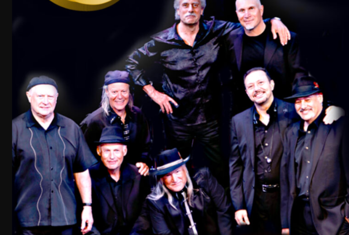 Eight group members wearing black, posing for a  photograph.