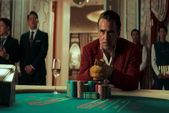 Person sitting at a gambling table with people watching them.