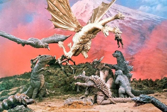 Epic monster fight with Godzilla, King Ghidorah, Rodan, and others in fiery sky near Mount Fuji.