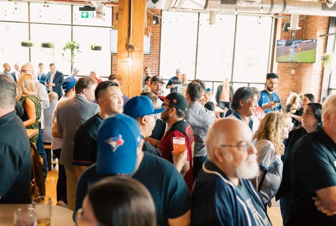 Crowded bar with fans in blue jerseys cheering drinking and watching game together in lively warm indoor setting.