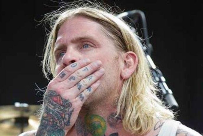 Brian Byrne covering his mouth with his tattooed hand.